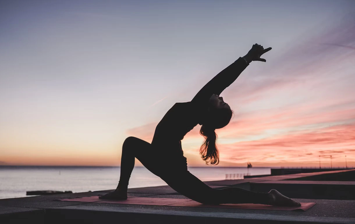 Jemand, der Dehnübungen auf einer Yogamatte macht.
